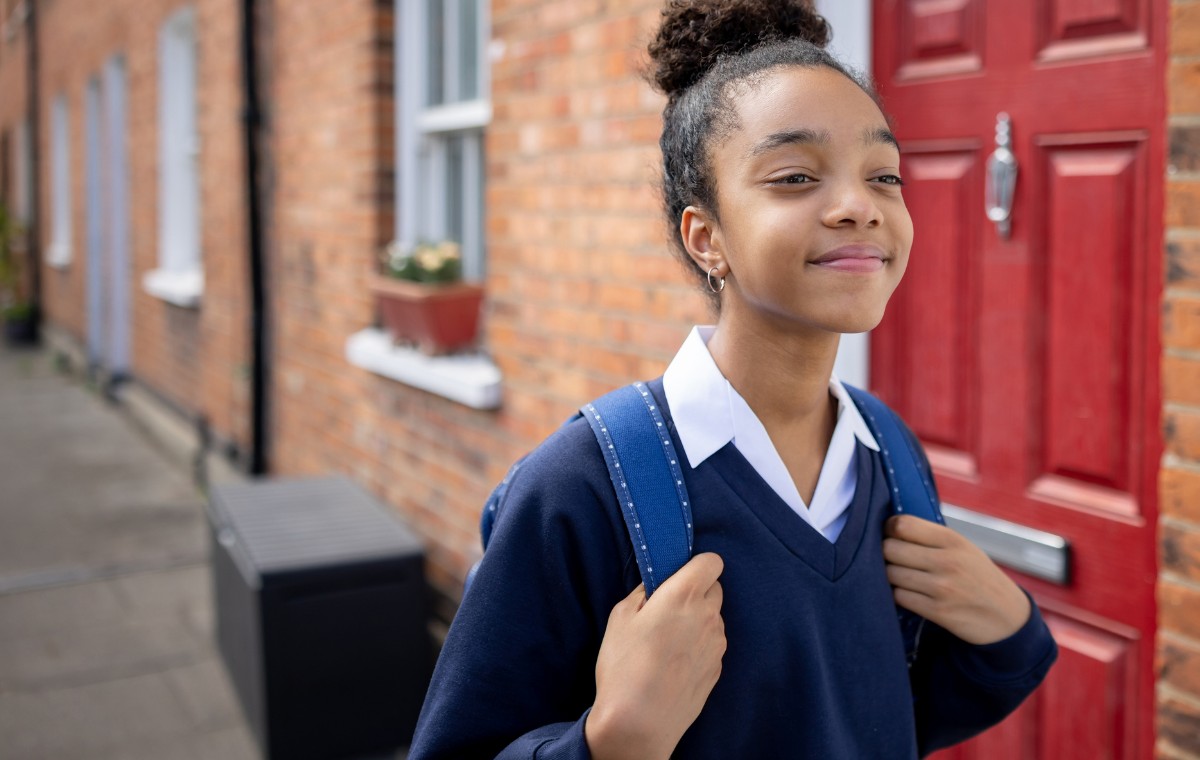 Happy teenage girl going to school